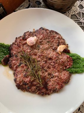 Turta şeklinde kıyma ya da hamburger sarımsak ve maydanoz soslu, Yahudi mutfağı.