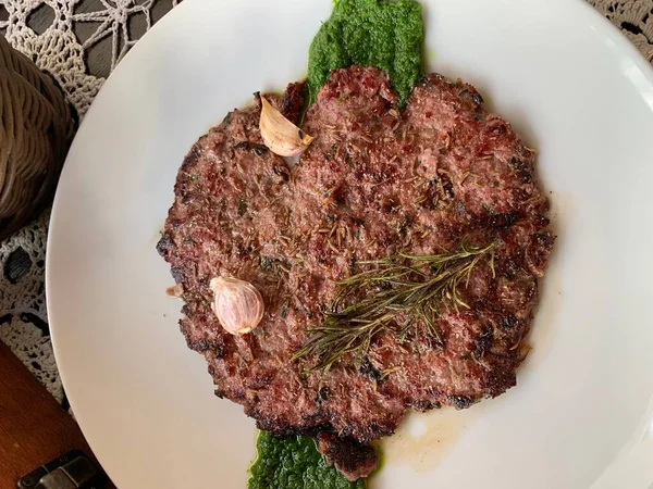 Turta şeklinde kıyma ya da hamburger sarımsak ve maydanoz soslu, Yahudi mutfağı.