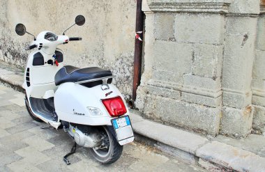 Caddeye park etmiş beyaz scooter, binanın duvarında, aynalar.