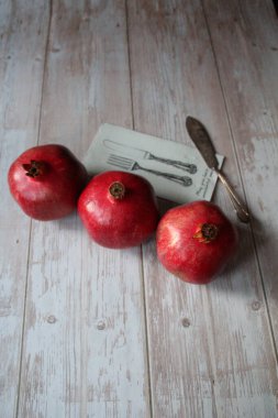 Üç güzel kırmızı el bombası, masada el bombaları, el bombalarının yanında eski bir bıçak, antika bir bıçak.