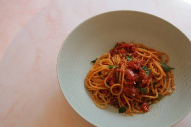 Bir tabak domates soslu spagetti, üzerine peynir ve maydanoz serpiştirilmiş, İtalyan makarna tabağı, basit İtalyan yemeği, tabakta karbonhidrat.
