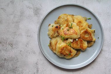 Kızarmış hamur köftesi, kızarmış soğanlı çıtır börek, üzerine yeşil soğan serpiştirilmiş sıcak hamur köftesi.