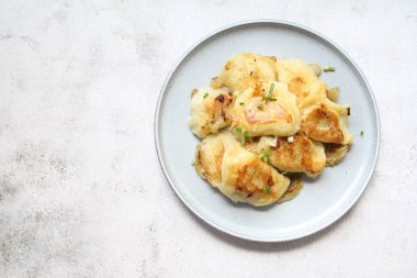 Kızarmış hamur köftesi, kızarmış soğanlı çıtır börek, üzerine yeşil soğan serpiştirilmiş sıcak hamur köftesi.