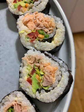 Renkli bir tabak suşi, ev yapımı suşi ton balığı, somon balığı, pilav.