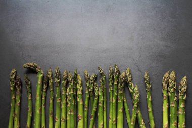 Yeşil kuşkonmaz, yeşil sebzeler, yenilebilir bitkiler, koyu gri arka plan, vitaminler.