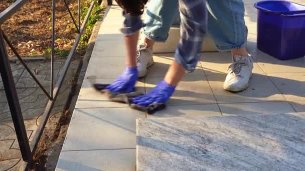 Cleaning the cemetery. A woman washes grey monument at grave with rag. — Stock Video