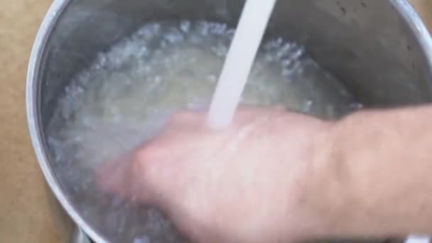 Рис, промитий проточною водою перед приготуванням . — стокове відео