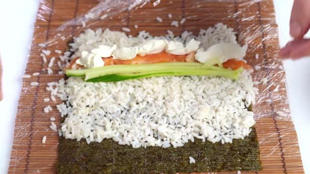 Matlagning rullar på en bambu matta hemma med egna händer. Japansk mat. — Stockvideo