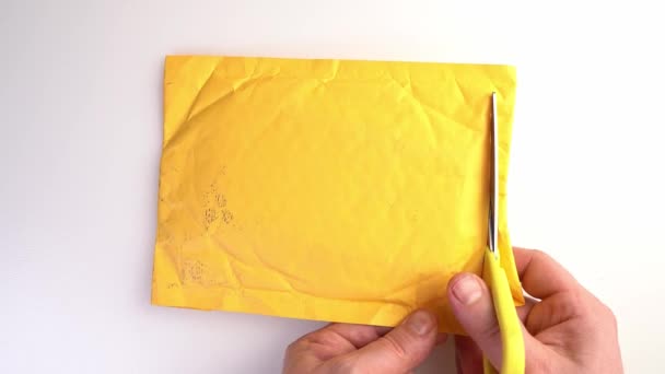Žlutý poštovní balíček posekaný nůžkami a vyndat pouzdro na smartphone. — Stock video
