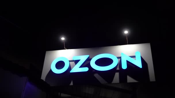 Het bord op het punt van het uitvaardigen van orders aan OZON in de avond op straat — Stockvideo