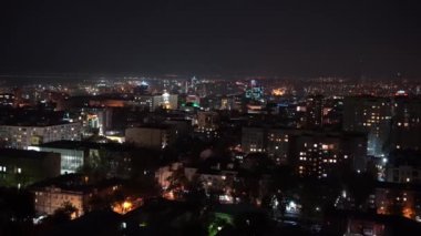 Yukarıdan ateş ediyorlar. Gece şehri. Işıklı. Komşuların pencereleri..
