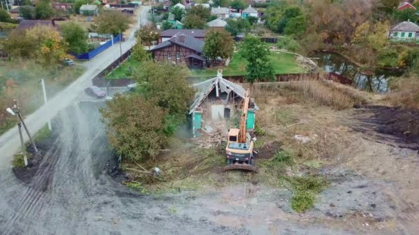Demolición de edificios. una excavadora rompe la antigua casa de pueblo. — Vídeo de stock