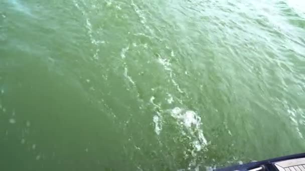Une poussée d'eau d'un hors-bord. un yacht à moteur se déplace le long de la rivière. — Video