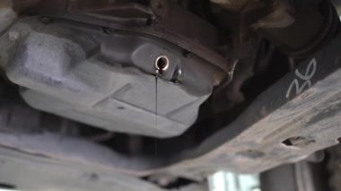 Arabadaki atık yağı boşaltılıyor. Bir benzin istasyonunda bakım.