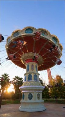 Lunaparkta geziyor. İnsanlar salıncaklara biner, rahatlar ve eğlenirler.. 