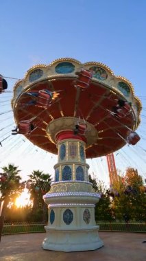 Lunaparkta geziyor. İnsanlar salıncaklara biner, rahatlar ve eğlenirler.. 