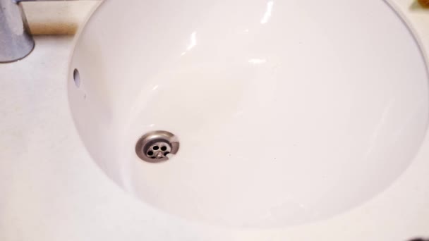 Ruce v rukavicích s hadrem a saponátem myje umyvadlo a kohoutek v koupelně. — Stock video