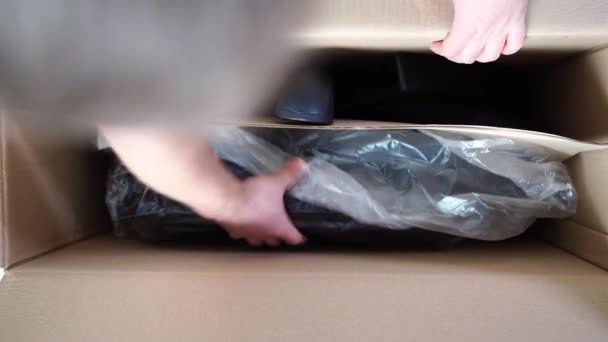 Een nieuwe bureaustoel wordt uit een kartonnen doos gehaald. — Stockvideo