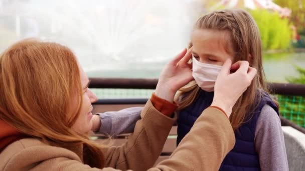 Mère enlève aux filles un masque jetable protecteur. — Video