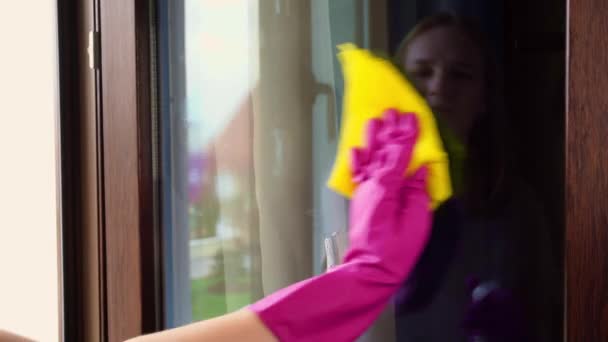 Kobieta w rękawiczkach myje szklankę na oknie.. — Wideo stockowe