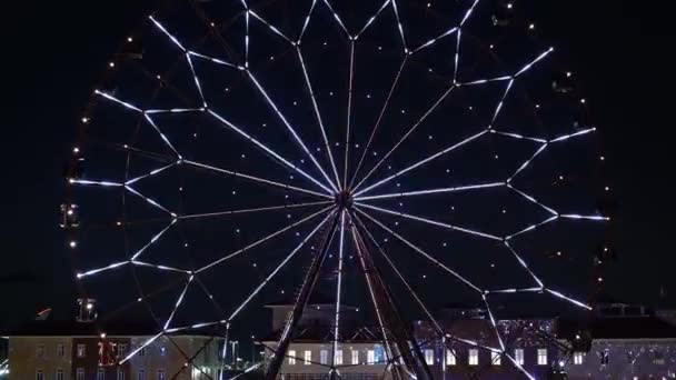 Ускорен. Чертово колесо с светящимися разноцветными огнями на фоне ночного неба — стоковое видео