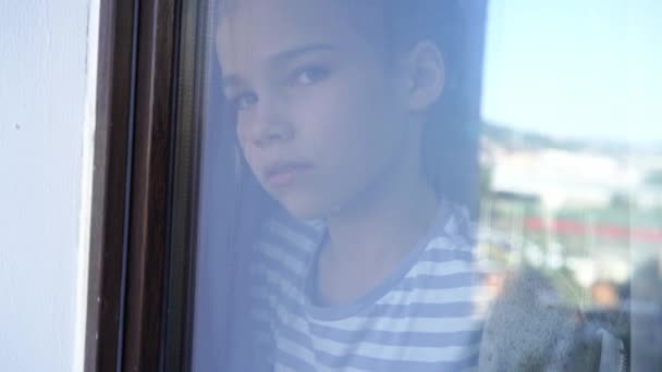Přes sklo. smutný dospívající dívka pohled z okna venku. — Stock video