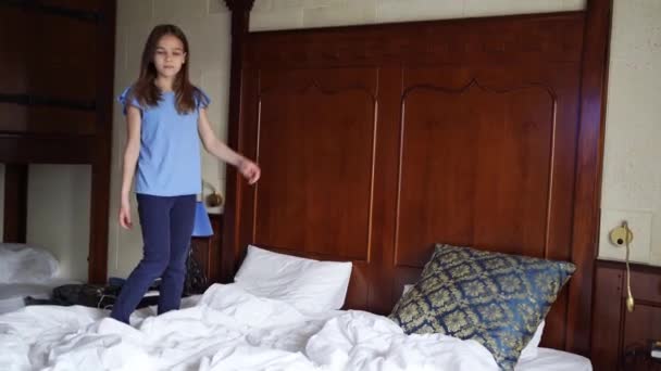 10代の女の子が落ちます,ジャンプ,いくつかの結果,大きな白いベッドの上にダブル. — ストック動画