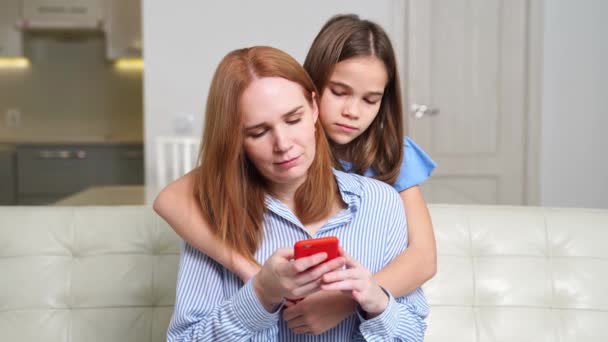 Maman et fille sur un smartphone, regarder des photos, des vidéos sur Internet — Video