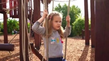 İp parkında bir kız oynuyor. Açık havada çocuklar için aktif, spor oyunları. 