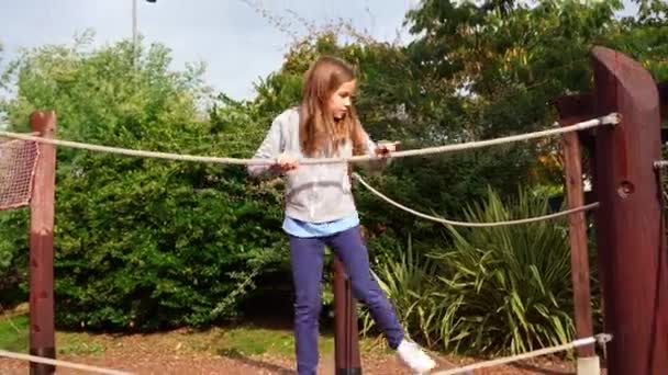 Dziewczyna bawi się w parku linowym. aktywne, gry sportowe dla dzieci na świeżym powietrzu. — Wideo stockowe