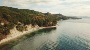 Denizin üzerinde uçmak ve dağlık bir orman bölgesinde vahşi bir plaj.. 