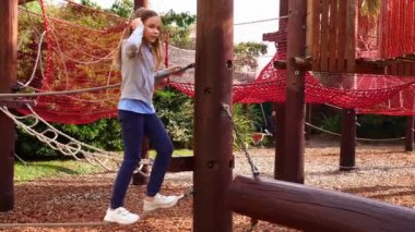 İp parkında bir kız oynuyor. Açık havada çocuklar için aktif, spor oyunları. 