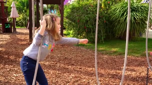 一个女孩在一个绳子公园里玩耍。户外运动供儿童参加的积极的体育活动. — 图库视频影像