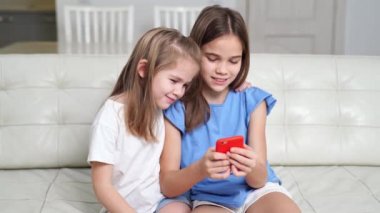 Akıllı telefonlu kızlar sosyal ağlarda komik videolar ve yayınlar izler.