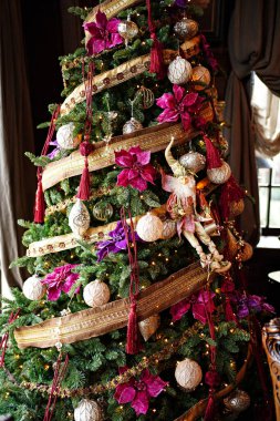 Eski tarz oyuncaklar ve çelenklerle süslenmiş Noel ağacı.