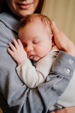 Mom gently holds on her kid in arm. long-awaited baby. Mothers Day.