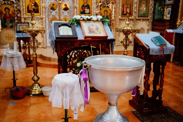 a font for baptism, an altar with a prayer book and icons in the church. 