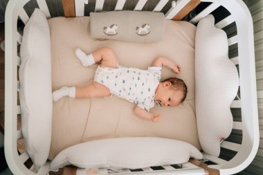 Üstten bak. Bebek karyolada. Çocuklar için uyuyacak bir yer ayarlamak..