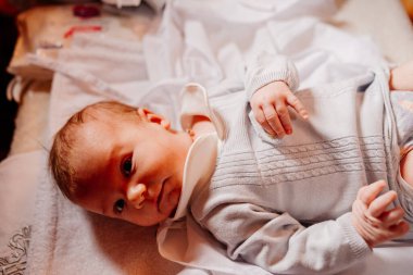 an infant is lying on a dressing table in the Church. the ordinance of baptism.