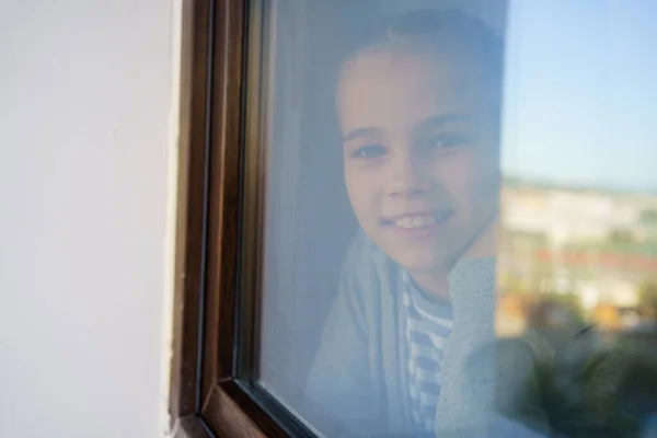 Через стекло. счастливая девочка-подросток, выглядывающая в окно. выздоровел. — стоковое фото