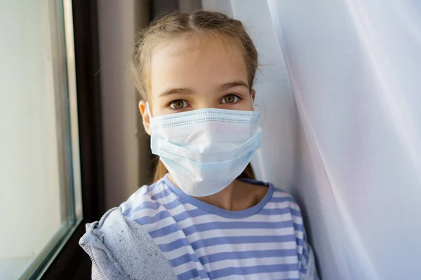 Una adolescente lleva una máscara médica protectora desechable. — Foto de Stock