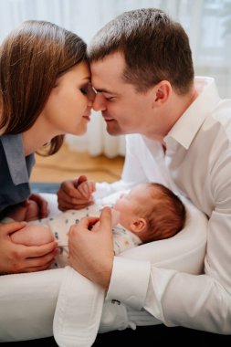 Happy parents with young son in a lounger for newborns. loving family
