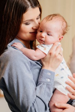 Mom gently holds on her kid in arm. long-awaited baby. Mothers Day.