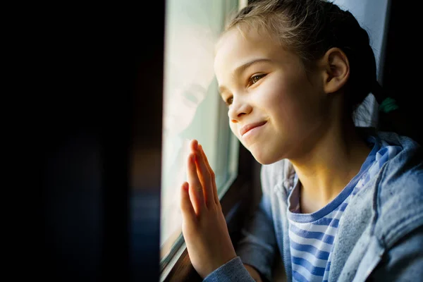 Счастливая девочка-подросток, выглядывающая в окно. выздоровел. — стоковое фото