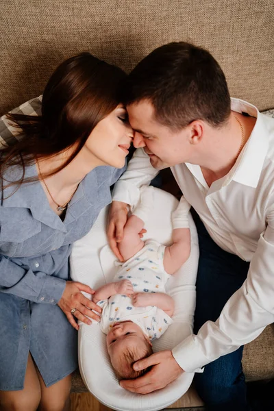 Στην κορυφή. Ευτυχισμένοι γονείς με μικρό γιο σε μια ξαπλώστρα για νεογέννητα. αγαπημένη οικογένεια — Φωτογραφία Αρχείου