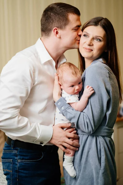 Mamma och pappa håller barnet i sina armar.. — Stockfoto