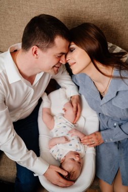 top view. Happy parents with young son in a lounger for newborns. loving family