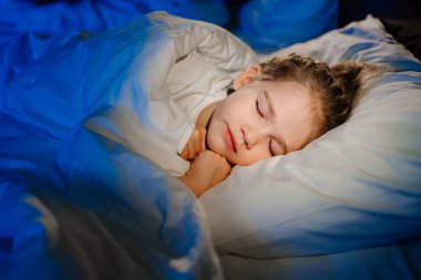 a cute little girl is sleeping in a bed. calm and healthy childrens sleep. 