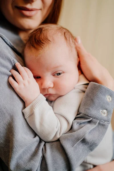 Mamá suavemente sostiene a su hijo en el brazo. tan esperado bebé. Día de las Madres. — Foto de Stock