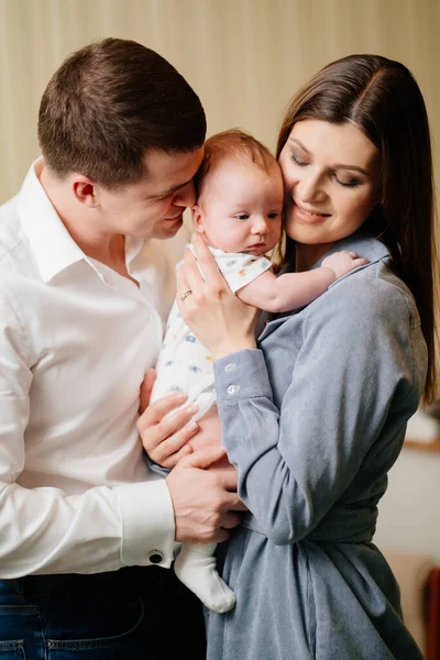 Mamá y papá sostienen en sus brazos al bebé. —  Fotos de Stock